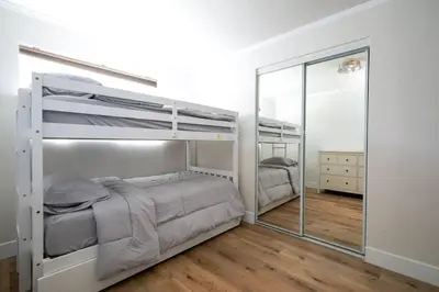 a bedroom with two bunk beds and a mirror at Beautiful Spacious Home in Los Angeles