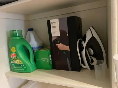 a shelf with a bottle of detergent and a book at Luxury 2 bedroom apartment in downtown LA! in Los Angeles