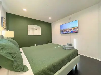 a bedroom with a bed with a television on the wall at 2BR Suite in the Heart of Hollywood -BR5 in Los Angeles