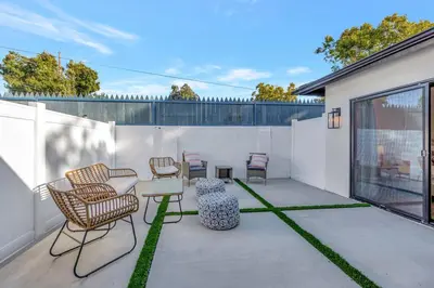 a patio with chairs and tables on a white wall at LA Home near Universal Studios and Hollywood in Los Angeles