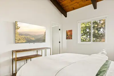 a white bedroom with a bed and a window at EV level 2, Pets Welcome at Sunset Ridge in Lake Arrowhead