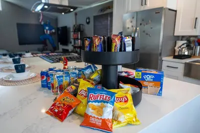 a kitchen counter with a pile of chips and snacks at Avengers Campus by OC Adventure Homes in Buena Park