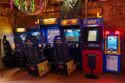 a bunch of video game machines in a room at Pirate Cove by OC Adventure Homes in Garden Grove