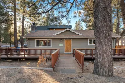a house with a wooden porch and a tree at Green Pines Lake Retreat Walk to Lake in Big Bear Lake