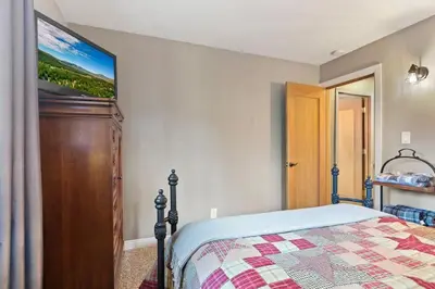 a bedroom with a bed and a painting on the wall at Green Pines Lake Retreat Walk to Lake in Big Bear Lake