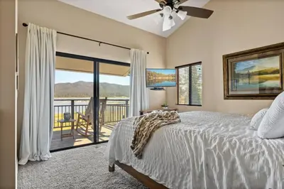 a bedroom with a bed and a balcony with a view at Lakefront at the Village in Big Bear Lake