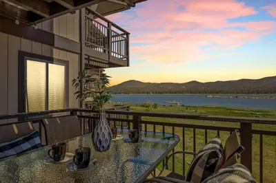 a table on a balcony with a view of the water at Lakefront at the Village in Big Bear Lake