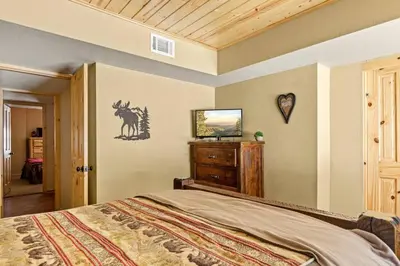 a bedroom with a bed and a tv on a wall at Slope Vista Escape in Fawnskin
