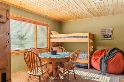 a dining room with a table and chairs and a bunk bed at Slope Vista Escape in Fawnskin