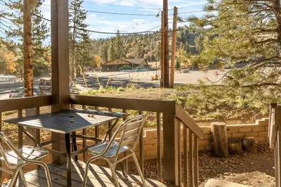 a table and chairs on a porch with a view of a street at NEW Summit Lookout in Big Bear Lake