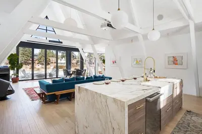 a kitchen and living room with a couch and a table at Mountain Top Modern Lakefront in Sunset Magazine in Big Bear Lake