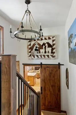 a chandelier hanging over a staircase in a house at Snowcrest Lodge in Exclusive Fox Farm in Big Bear Lake