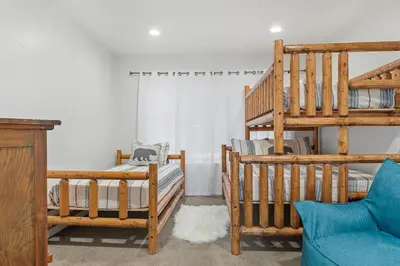 a room with two bunk beds and a ladder at HoneyBear Lodge Lakefront in Big Bear Lake