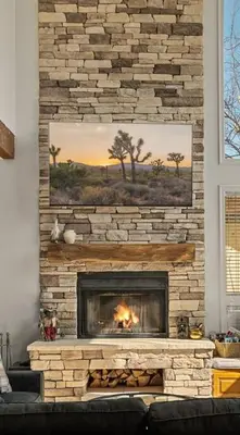 a living room with a stone fireplace with a painting at HoneyBear Lodge Lakefront in Big Bear Lake