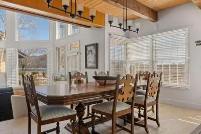 a dining room with a table and chairs and windows at HoneyBear Lodge Lakefront in Big Bear Lake
