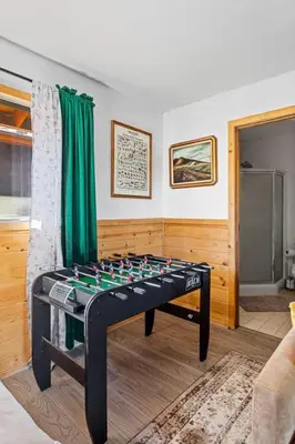 a game table in a living room with green curtains at Honeybee by the Bay in Big Bear Lake in Big Bear Lake