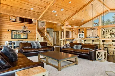 a living room with leather couches and a table at Hidden Haven Estate in Big Bear Lake