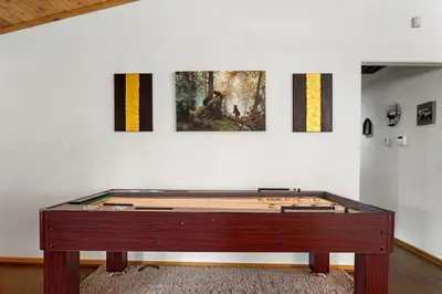 a ping pong table in front of a wall with paintings at Fallen Leaf Hideaway Castle Estate in Big Bear Lake