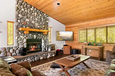 a living room with a stone fireplace in a cabin at Fallen Leaf Hideaway Castle Estate in Big Bear Lake