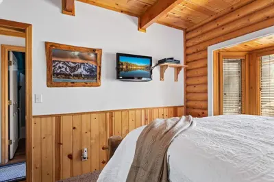 a bedroom with a bed and two televisions on the wall at Bear Kub Kabin in Big Bear Lake