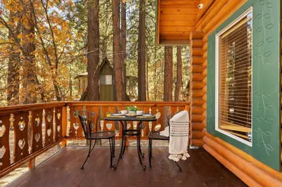 a porch of a cabin with a table and chairs at Bear Kub Kabin in Big Bear Lake