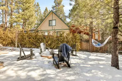 a yard with chairs and a hammock in the snow at Zen Mountain Retreat in Big Bear Lake