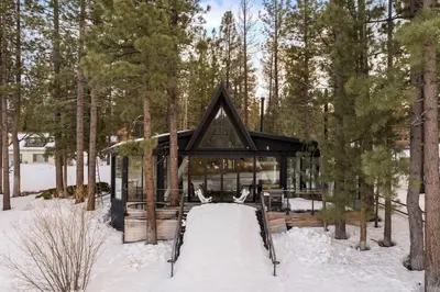 a house in the woods in the snow at Lakefront Modern A Frame in Big Bear Lake