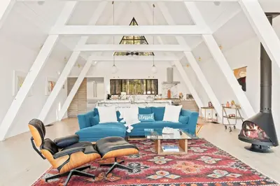 a living room with a blue couch and a fireplace at Lakefront Modern A Frame in Big Bear Lake