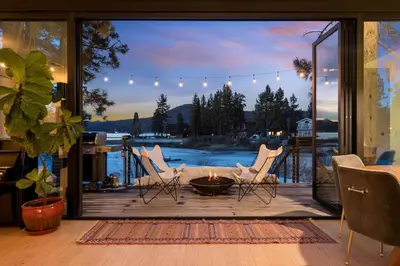 a patio with white chairs and a fire pit at Lakefront Modern A Frame in Big Bear Lake