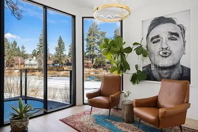 a living room with two chairs and a large window at Lakefront Modern A Frame in Big Bear Lake