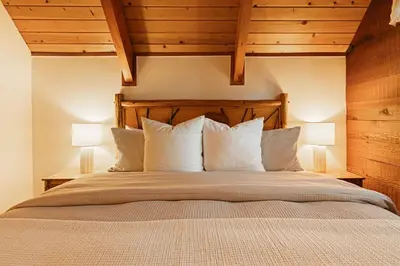 a bedroom with a large bed with two lamps at Knoll Lake Cabin in Big Bear Lake in Big Bear Lake