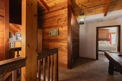a room with wooden walls and a mirror and a bedroom at Knoll Lake Cabin in Big Bear Lake in Big Bear Lake