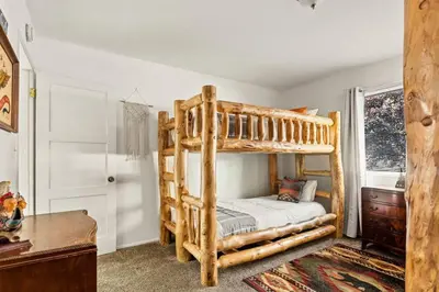 a bedroom with two bunk beds and a desk at Fawnskin Forest Haven in Fawnskin