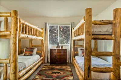 a bedroom with two bunk beds and a window at Fawnskin Forest Haven in Fawnskin