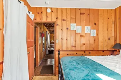 a bedroom with a bed and wooden walls at Tree Top Ranch in Big Bear Lake