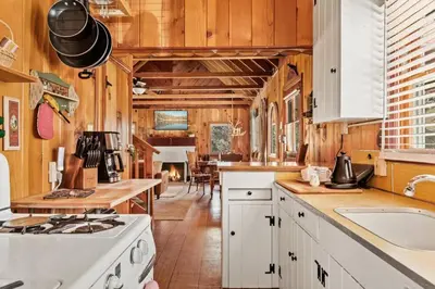 a kitchen with white appliances and wooden walls at Tree Top Ranch in Big Bear Lake