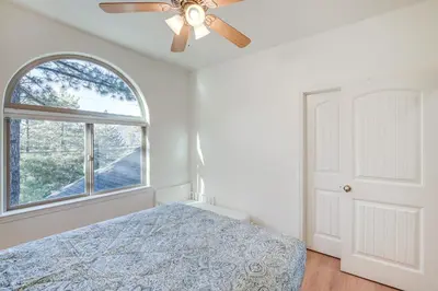 a bedroom with a bed and a ceiling fan at Serene Pine Mountain Club Home with Pool Access! in Pine Mountain Club