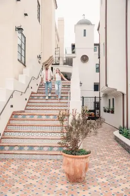 a man and woman walking down the stairs of a building at Hotel San Buena in Ventura