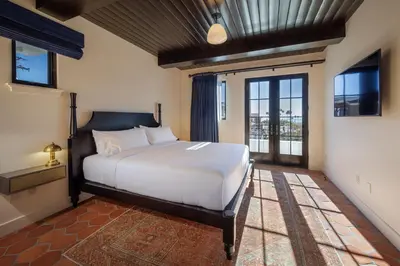a bedroom with a large white bed and windows at Hotel San Buena in Ventura