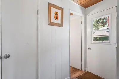 a white hallway with a door and a window at The Teddy Bear Cabin! Large Patio! in Big Bear City