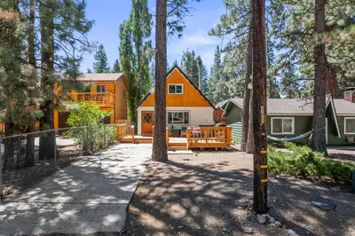 a house in the woods with a porch at The Teddy Bear Cabin! Large Patio! in Big Bear City