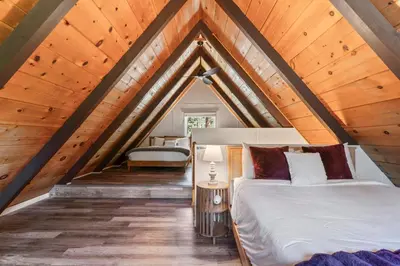 a bedroom with a bed in a attic at The Teddy Bear Cabin! Large Patio! in Big Bear City