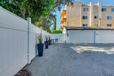 a white fence and a driveway with a garage at Van Nuys Abode with Patio, 7 Mi to Universal Studios in Van Nuys