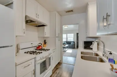 a kitchen with white cabinets and a sink at Van Nuys Abode with Patio, 7 Mi to Universal Studios in Van Nuys