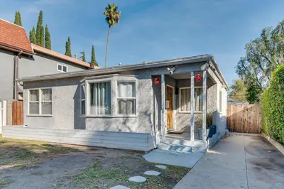 a small house with a fence and a palm tree at North Hollywood Getaway 14 Mi to Downtown! in North Hollywood