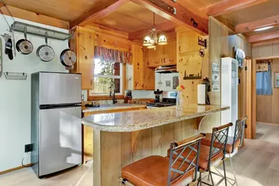 a kitchen with a counter and a refrigerator at Kozy Cabin Big Bear~ Walk to Village & Lake Cottage~ in Big Bear Lake