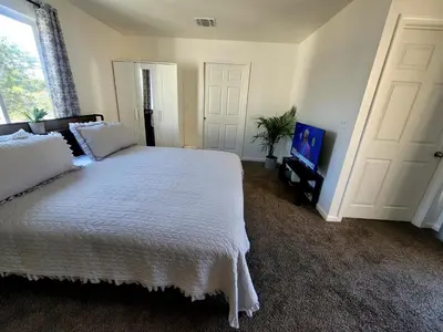 a bedroom with a large white bed and a tv at 4 Bedrooms & 2.5 Bathrooms in LA in Los Angeles