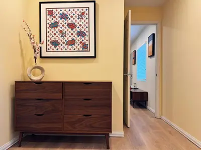 a hallway with a dresser and a painting on the wall at Hollywood Hills Haven-Guest House in Los Angeles