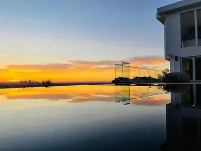 a reflection of a building in the water at sunset at Hollywood Hills Haven-Guest House in Los Angeles