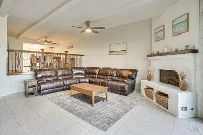 a living room with a leather couch and a fireplace at Huntington Beach Condo - Walk to the Ocean! in Huntington Beach